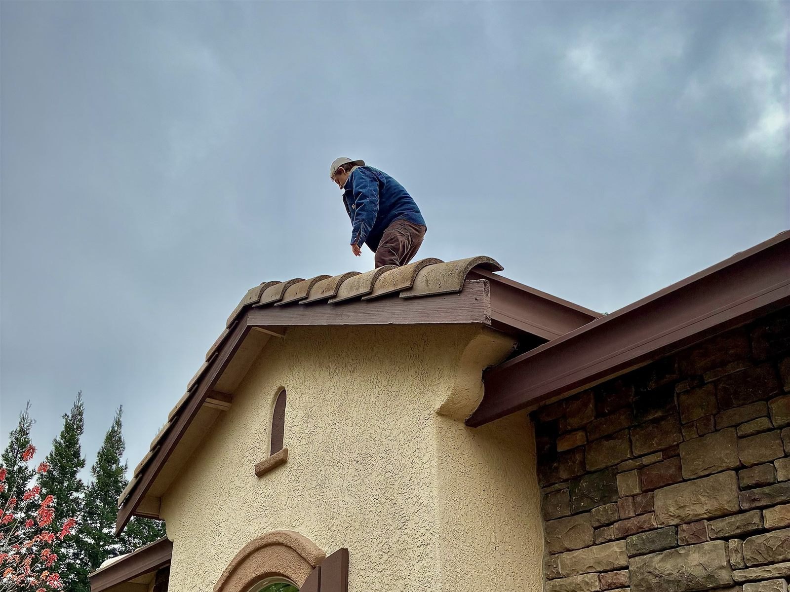 Zach on a tile roof installing C9 lights on a sunny day