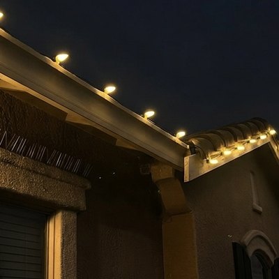 Warm white C9 bulbs glowing along an eave at night