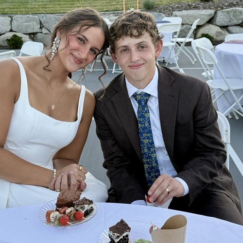 Zach and Brooklyn smiling together at a table at their wedding reception